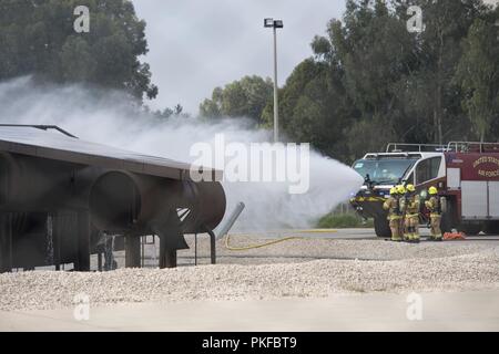 Mitglieder des 39. Bauingenieur Squadron Feuerwehr nutzen einen Absturz Ausschreibung, die eine simulierte Flugzeuge Brand in Incirlik, der Türkei, August 7, 2018. Die Feuerwehr Mitglieder verwendet die Ausübung der Reaktionszeit und der Praxis mit ihren Anlagen zu verringern, um sicherzustellen, dass sie ausreichend ausgebildet. Stockfoto