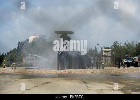 Mitglieder des 39. Bauingenieur Squadron Feuerwehr Arbeit zu setzen, ein simuliertes Flugzeug Brand in Incirlik, der Türkei, August 7, 2018. Die Abteilung Training Manager hatte die volle Kontrolle über die simulierte Feuer, so dass die Feuerwehrleute die realistische Flugzeug Feuer Erfahrung erhalten. Stockfoto