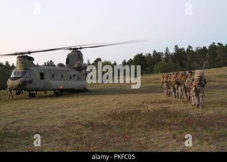 CAMP ÄSCHE, Mich - Soldaten aus unterstützen Bataillon, 3. Brigade, die lettische Armee, begeben Sie sich an einen CH-47 Chinook in Vorbereitung auf eine 5-tägige Schulung Iteration im Camp Äsche, mich auf August 9, 2018. In den USA und lettische Soldaten beteiligen sich an der nördlichen Streik, eine gemeinsame, multinationalen, kombinierte Waffen live Fire Training durch die Michigan National Guard gehostet werden. Stockfoto