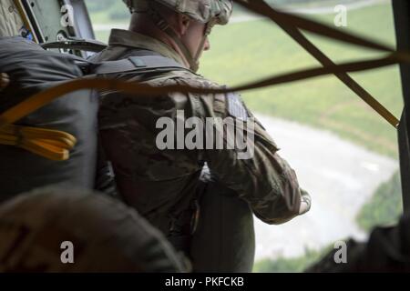 Ein Fallschirmjäger der US-Armee in die 4 Infantry Brigade Combat Team (Airborne), 25 Infanterie Division, U.S. Army Alaska zugeordnet, bereitet aus einer Illinois Air National Guard C-130 Hercules aus Peoria Air National Guard Base, Peoria, Illinois zu springen, während der Durchführung der Luft Ausbildung bei Joint Base Elmendorf-Richardson, Alaska, Aug 8, 2018. Die Soldaten der 4/25 gehören zu den nur American Airborne Brigade im Pazifik und sind geschult in der Luft Manöver bei extrem kalten Wetter und Höhenlage Umgebungen zur Unterstützung der Bekämpfung, Partnerschaft und Katastrophenhilfe Operationen auszuführen. Stockfoto