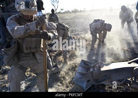 Lance Cpl. Michael J. Kohler, ein gezogenes Artillerie system Techniker mit Mike Batterie, 3.Bataillon, 11 Marine Regiment, 1st Marine Division, gräbt eine Verankerung für die M777 Haubitze als die Marines eine Schussposition während der Ausbildung Aug 8, 2018, am Mount Bundey, Northern Territory, Australien. Dies ist das erste Mal, dass eine gesamte Artillerie Batterie zur Unterstützung der Marine die Drehkraft - Darwin bereitgestellt und zeigt, wie die Marine Air-Ground Task Force ausgestattet und organisiert nationale Ziele in Zusammenarbeit mit internationalen Partnern zu führen. Stockfoto