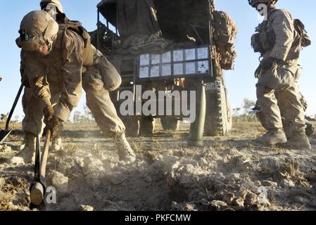 Lance Cpl. Michael J. Kohler, ein gezogenes Artillerie system Techniker mit Mike Batterie, 3.Bataillon, 11 Marine Regiment, 1st Marine Division, bricht Schmutz mit einem pickel beim Graben eine Verankerung für die M777 Haubitze als die Marines eine Schussposition während der Ausbildung Aug 8, 2018, am Mount Bundey, Northern Territory, Australien. Dies ist das erste Mal, dass eine gesamte Artillerie Batterie zur Unterstützung der Marine die Drehkraft - Darwin bereitgestellt und zeigt, wie die Marine Air-Ground Task Force ausgestattet und organisiert nationale Ziele in Zusammenarbeit mit intern durchführen Stockfoto