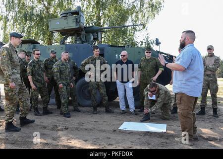 Bobby Lightner, zweite rechts, eine Auswahl und Ausbildung Land Programm Spezialist mit der US Army Training Support Aktivität Europa (TSAE) und Soldaten aus Litauen, Tschechien und den Niederlanden ein Tank Bereich Trockenlauf am Pabrade, Litauen, Aug 09, 2018 diskutieren. TSAE durchgeführt eine Endprüfung der neu errichteten Anlage als TSAE ist Unterstützung von NATO-Verbündeten in Osteuropa entwickeln ihre Auswahl und Ausbildung Infrastrukturen. Stockfoto