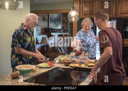 Airman 1st Class Curtis Jones, 334 Aircraft Maintenance Unit, hilft das Abendessen mit seinen Sponsoren, Tim und Donna Malloy, an der Malloy residence Aug 4, 2018, in Pikeville, North Carolina vorbereiten. Jones ist einer von mehr als 10 Flieger, die derzeit von einer lokalen Familie als Teil der Seymour Johnson Air Force Base Airman Sponsoring Programm, das entworfen ist, um die Flieger mit einer Allee zu stellen neue Freundschaften in der lokalen Gemeinschaft zu bilden und zu unterstützen, die über die formalen Arbeitsumgebung sammeln gefördert. Stockfoto