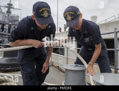 Virginia (Aug. 03, 2018) Elektroniker 3. Klasse Matios Ishou, aus Detroit, Links, und der bootsmann Mate 3. Klasse Taylor Curtisware, aus Chattanooga, Tennessee, Moore die geführte-missile Cruiser USS Vella Golf (CG72) zum Pier. Vella Golf ist derzeit pier Seite an die Norfolk Naval Station. Stockfoto