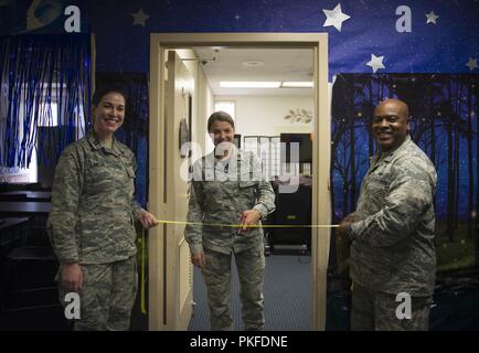 Kaplan, Kapitän Molly Lawlor, 99th Air Base Wing Kaplan, Maj. Maria Mangum, 99th ABW Comptroller Squadron Commander, und Kaplan, Oberstleutnant Dwayne Jones, 99th ABW Flügel Kaplan, schneiden Sie ein Band bei der Eröffnung des Nellis Kapelle Stillzeit Zimmer auf der Nellis Air Force Base, Nevada, 3. August 2018. Nellis hat beschlossen, die diesjährigen Nationalen stillen Monat durch die Bereitstellung von neuen und verbesserten private Stillzeit Zimmer auf Basis für stillende Mütter zu feiern. Stockfoto