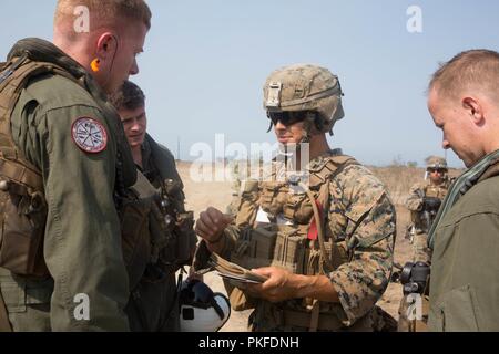 Kapitän David Skaggs, Links, Ein CH-53E Super Stallion Pilot mit Marine schweren Helikopter Squadron (HMH) 465, Marine Flugzeuge Gruppe 16, 3. Marine Flugzeugflügel, der ausbildungsplan mit Cpl diskutiert. Antonio Rojas, eine schnelle - roping Master mit Amphibischen Raids Zweig, Expeditionary Operations Training Group (EOTG), ich Marine Expeditionary Force, in der Marine Corps Base Camp Pendleton, Calif., Aug 10. HMH-465 führt das Training mit EOTG zum fußvolk Marines unterstützen schnelle-Seil von einem Hubschrauber. Stockfoto