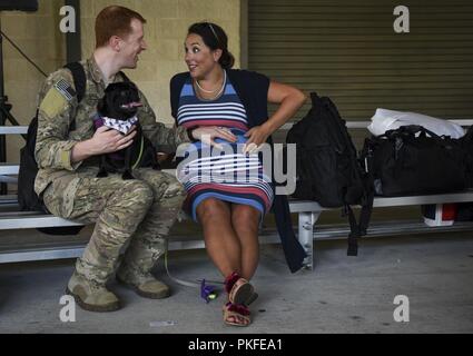 Us Air Force Maj. Clayton Ten Eyck, eine AC-130 U Spooky gunship Evaluator Pilot mit der 4 Special Operations Squadron, vereint mit seiner Frau während der Operation Homecoming an hurlburt Field, Florida, Aug 9, 2018. Familie und Freunde von mehr als 80 Air Commandos versammelten Hause begrüßen zu dürfen ihre Lieben aus einer Bereitstellung. Stockfoto