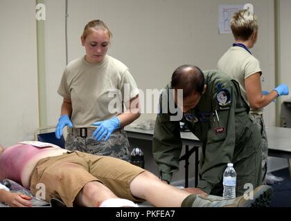 Mitglieder des Medical Group, 185 Luftbetankung Flügel, Sioux City, Ia., beteiligen sich an der Savannah Sturm Übung an der Savannah Air National Guard Base in Georgien. Oberstleutnant Mohan Akella, triage Arzt, schreibt seine Behandlung Bewertung während Flieger 1. Klasse Shanah Herman, triage Mitarbeiter, Vitalparameter des Patienten beendet. Stockfoto