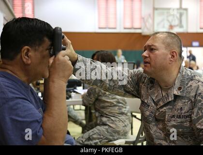 Us Air Force Maj. Derek Melton, ein Optiker die 181St Medical Group, Indiana Air National Guard zugewiesen, führt eine Augenuntersuchung auf einen Patienten Aug.11, 2018 in Lanai City, HI. Tropic Care Maui County 2018 bietet medizinische Service Mitglieder- und Supportpersonal in "hands-on"-Readiness Training für zukünftige Bereitstellungen zu, während für direkte und dauerhafte Vorteile für die Bevölkerung von Maui, Molokai und Lanai, August 11-19 vorbereiten. Stockfoto