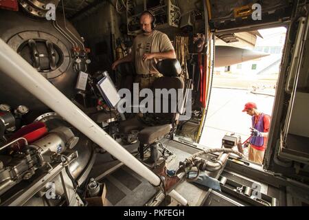 Us Air Force Master Sgt. Jason Wales, eine C-130 Lademeister aus Die 153 Airlift Wing, Wyoming Air National Guard, Uhren als MAFFS 9, ein modulares luftgestützten Brandbekämpfung System ausgestattete C-130 von die 152. Airlift Wing, Nevada Air National Guard, mit Feuerhemmendem, Mittwoch, 8. August 2018 neu geladen wird, bei der U.S. Forest Service San Bernardino Airtanker Base in San Bernardino, Kalifornien. Die Flugzeuge, die Crew Mitglieder sowohl von der Nevada und Wyoming Air National Guards, half das heilige Feuer in Südkalifornien Schlacht. Stockfoto