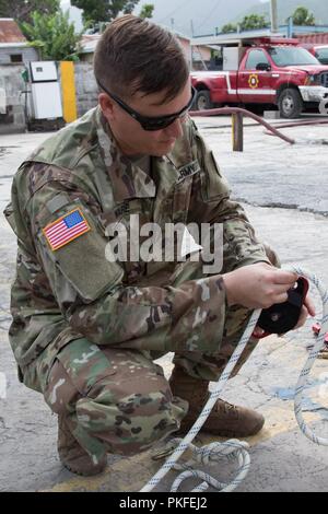 Sgt. Andrew Ware, Teammitglied mit den chemischen, biologischen, radiologischen, nuklearen Sprengstoff enhanced Response Force Paket (CERFP), beauftragt und zeigt, wie rig ein Seil an einem Flaschenzug für Seil Extraktionen für die Mitglieder der St. Kitts und Nevis Fire Rescue Services (SKNFRS). Stockfoto