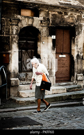 Eine alte Frau in der mittelalterlichen Stadt Semur-en-Auxois, in der Côte d'Or (Frankreich, 24/06/2010) Stockfoto