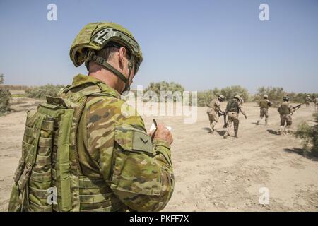 Eine australische Armee Trainer, mit Task Group Taji, beobachtet, irakische Soldaten an 2nd Battalion, 59th Brigade, Patrouille während einer bestätigenden Ausbildungstätigkeit an Camp Taji, Irak, 30. Juli 2018. Durch beschleunigte Erfolge gegen ISIS im Jahr 2017 aktiviert, Koalition Unterstützung für unsere Partner entwickelt, wie wir unsere Partner bei der Bereitstellung von Sicherheit, die Stabilisierung unterstützen. Stockfoto