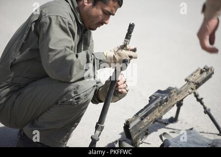 KANDAHAR AIR WING, Afghanistan (Aug. 5, 2018) Einen afghanischen Luftwaffe UH-60 crewmember prüft seine M240 Maschinengewehr während eines Pre-flight Inspection 5. August 2018, Kandahar Air Wing, Afghanistan. Die crewmember ist in der Mission Qualifizierungsmaßnahmen, die hilft, den Afghanischen UH-60 Crewmitglieder Bekämpfung bereit zu sein. Stockfoto