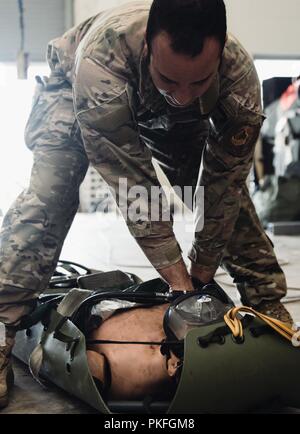 Staff Sgt. Michael Galindo, 320 Spezielle Taktiken Squadron pararescueman, überprüft den Puls einer trainingspuppe während einer Rettung Taktiken Demonstration, 10.08.2018, bei Kadena Air Base, Japan. Ein Such- und Rettungskräfte waren der Tham Luang Höhle im Norden von Thailand auf Wunsch der thailändischen Regierung in die Rettung von vermissten Thai Fussball Spieler und ihre Trainer zu unterstützen. Stockfoto