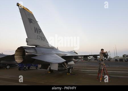 Us Air Force Senior Airman Levi Dimaria, 80 Aircraft Maintenance Unit Waffen laden Crew Chief, führt Wartungsarbeiten an einer F-16 Fighting Falcon vor der Dämmerung während der Übung Pitch Black 2018 Royal Australian Air Force Base Darwin, Australien, 31. Juli 2018. Insgesamt etwa 140 Flugzeuge beteiligen sich Pitch Black 18, US Air Force und US Marine Corps Fighter und Bomber Strahlen zu gehören, Tanken und Drehflügler und der Unterstützung von Bodentruppen. Stockfoto