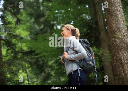 Eine glückliche Frau Wandern im Wald Stockfoto