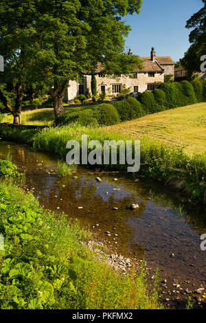 England, Yorkshire, Wharfedale, Linton im Craven, aus Stein gebaute Eigenschaften neben Linton Beck Stockfoto