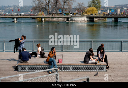 Die Menschen genießen die Sonne auf der Pont de la Machine über die Rhône in Genf (Schweiz, 16/04/2010) Stockfoto