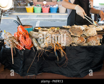 Gesunde verschiedene Meeresfrüchte Verkauf auf der Straße Markt in der Stadt Phuket, Thailand. Jakobsmuscheln, achelata, Hummer und Scampi auf Zähler zum Kochen Stockfoto