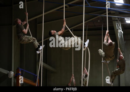 Marine Commandos klettern Seile als Herzog von Sussex Besuche der Royal Marines Commando Training Center in Lympstone, Devon. Stockfoto