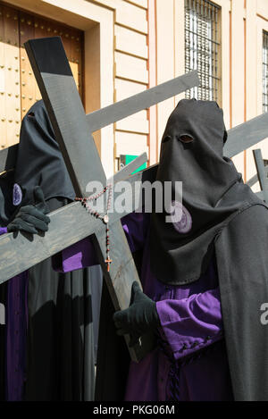 Büßer mit Kreuz und Rosenkranz in der Semana Santa, der Karwoche, Sevilla, Andalusa, Spanien Stockfoto