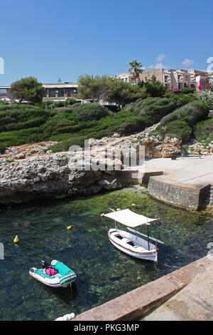 Spanien, Balearen. Menorca. Binebeca. Binebequer-Vell. Cove mit Fischerbooten und Hotel Komplex. Stockfoto