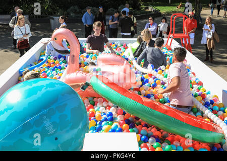 Southbank, London, UK, 13. Sep 2018. Leute haben Spaß mit ay Kugeln zu langweilig' in London an der Sonne. Angeblich größte Outdoor ball Pit in Großbritannien zu sein, öffnet sich auf der Southbank heute in London. Die Grube enthält 140.000 bunte Kugeln für eine 'kidult Lido", in dem Besucher ein erfrischendes Bad nehmen können. Credit: Imageplotter Nachrichten und Sport/Alamy leben Nachrichten Stockfoto