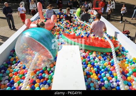 Southbank, London, UK, 13. Sep 2018. Leute haben Spaß mit ay Kugeln zu langweilig' in London an der Sonne. Angeblich größte Outdoor ball Pit in Großbritannien zu sein, öffnet sich auf der Southbank heute in London. Die Grube enthält 140.000 bunte Kugeln für eine 'kidult Lido", in dem Besucher ein erfrischendes Bad nehmen können. Credit: Imageplotter Nachrichten und Sport/Alamy leben Nachrichten Stockfoto