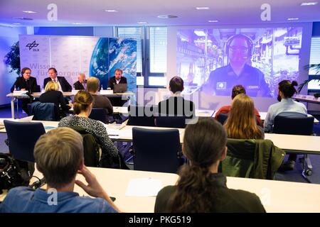 13. September 2018, Bremen: Forscher und Journalisten sitzen in einem Raum auf der Pressekonferenz auf der Antarktischen Gewächshaus stehen und zum Weltraum Ingenieur Paul Zabel, die auf einem Bildschirm während einer Live-Übertragung in die Antarktis gesehen werden kann. Seit Anfang des Jahres hat er wachsenden Salat, Gurken, Tomaten, Paprika und Kräuter in der Nähe der Deutschen Polarstation Neumayer III. Das Projekt des Deutschen Zentrums für Luft- und Raumfahrt ist ein Testlauf für künftige Mars-Missionen betrachtet. Foto: mohssen Assanimoghaddam/dpa Stockfoto