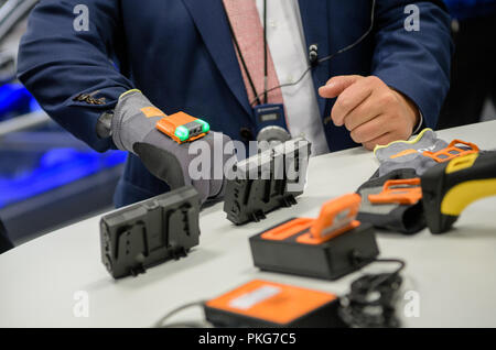 Dingolfing, Bayern. 13 Sep, 2018. 13. September 2018, Deutschland, Dingolfing: Franz Josef Pschierer (CSU), Bayerischer Staatsminister für Wirtschaft, versucht, ein Handschuh mit einem integrierten hand scanner bei einem Besuch im BMW Werk. Mit 17.500 Mitarbeitern und rund 360.000 Fahrzeuge pro Jahr, das Werk Dingolfing ist BMW größten Produktionsstandort in Europa. Credit: Matthias Balk/dpa/Alamy leben Nachrichten Stockfoto