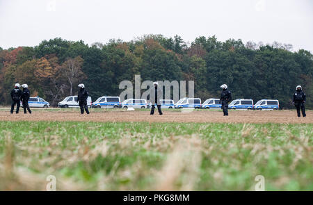 13. September 2018, Nordrhein-Westfalen, Kerpen: 13. September 2018, Deutschland, Kerpen: Polizisten stehen vor Ihrer Einsatzfahrzeuge auf einem Feld vor der Hambach Wald. Mit einer massiven Polizeipräsenz, die Behörden im Braunkohlerevier Hambach Wald begonnen haben barrikaden die Umweltaktivisten' zu löschen. Foto: Marcel Kusch/dpa Stockfoto