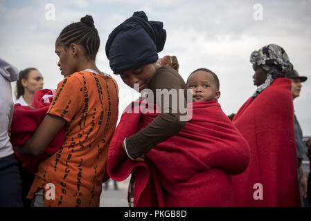 Motril, Granada, Spanien. 13 Sep, 2018. Sahara Frau gesehen, die ihr Baby mit einer roten Decke nach gerettet werden.79 Migranten gerettet in der Alboran See durch Maritime Rescue Team wurden am Hafen von Motril in der Nähe von Granada. Credit: Carlos Gil/SOPA Images/ZUMA Draht/Alamy leben Nachrichten Stockfoto