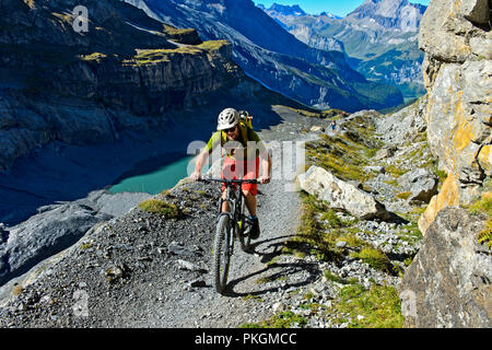 Ein Mountainbike rider auf einer einzelnen Spur auf der Seitenmoräne des Gletschers Blüemlisalpgletscher, Kandersteg, Schweiz Stockfoto