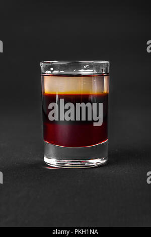 Mehrfarbig geschichtete Cocktail, Glas mit transparenten und farbigen Drink mit dem Geschmack von Kaffee, Beeren, Kirschen, Zitronen, alkoholische, Seitenansicht Isola Stockfoto