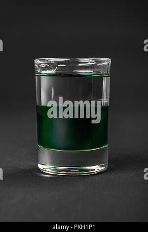 Mehrfarbig geschichtete Cocktail, Glas mit transparenten und farbigen Drink mit Minzgeschmack, Absinth, alkoholische, Seitenansicht isolierte schwarze Hintergrund Stockfoto