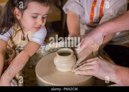 Keramik Klasse und Workshop: Professionelle männlichen Potter, die mit Kindern arbeiten und zeigen, wie keramische Waren in der Keramik Studio zu machen. Handgefertigte, educatio Stockfoto