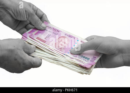 Hand geben Indische 500 und 2000 Rupien Banknoten über Weizen Hintergrund. Konzept für das Ergebnis oder verbringen Sie in der Landwirtschaft. Stockfoto