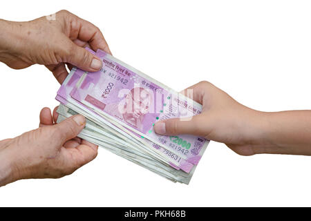 Hand geben Indische 500 und 2000 Rupien Banknoten über Weizen Hintergrund. Konzept für das Ergebnis oder verbringen Sie in der Landwirtschaft. Stockfoto