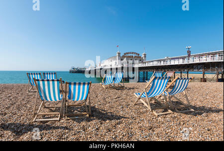 Brighton Palace Pier, Leere Liegestühle und Strand im Sommer in Brighton Beach, Brighton, East Sussex, England, UK. Stockfoto