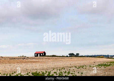 Gran's Hütte. Eine geriffelte schwarze und rote Hütte auf einen Kiesstrand bei Roggen Hafen, Hafen Nature Reserve Rye, East Sussex, England. 30. August 2018 Stockfoto