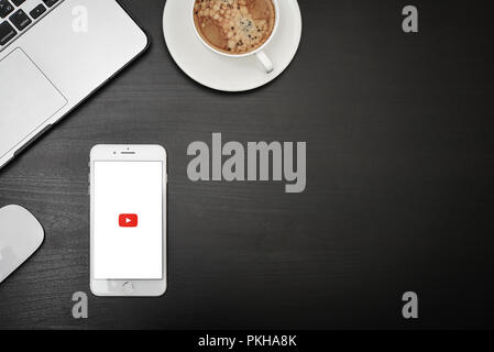 Kiew, Ukraine - Februar 6, 2018: Apple iPhone 8 plus mit YouTube App auf dem Bildschirm liegen auf schwarzen Schreibtisch mit Kopfhörern und Kaffee, Ansicht von oben. YouTube Stockfoto