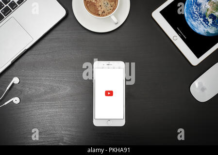 Kiew, Ukraine - Februar 6, 2018: Brand new Apple iPhone 8 plus mit YouTube App auf dem Bildschirm liegen auf schwarzen Schreibtisch mit Kopfhörern, MacBook Pro und iP Stockfoto