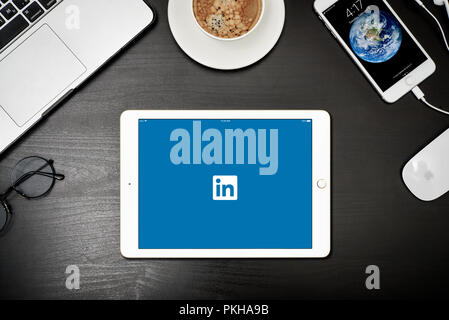 Kiew, Ukraine - Februar 6, 2018: Apple iPad Gold mit Linkedin App auf dem Bildschirm auf schwarz Schreibtisch mit dem MacBook und iPhone, Ansicht von oben. Linkedin ist eine socia Stockfoto