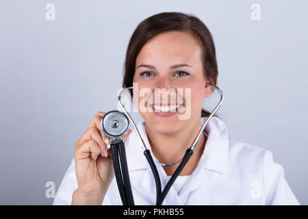 Portrait eines glücklichen jungen Arzt Holding Stethoskop Stockfoto
