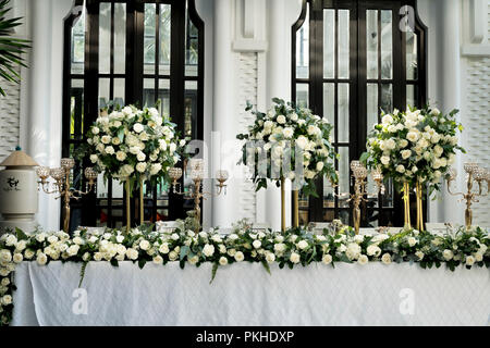 Die Vasen mit vielen Blumen weiße Rosen stehen auf den Hochzeitstisch Stockfoto