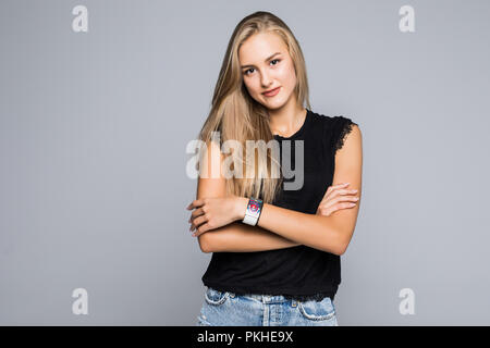 Portrait von sehr trendy Frau mit dem strahlenden Lächeln mit verschränkten Armen an der Kamera auf grauem Hintergrund suchen Stockfoto