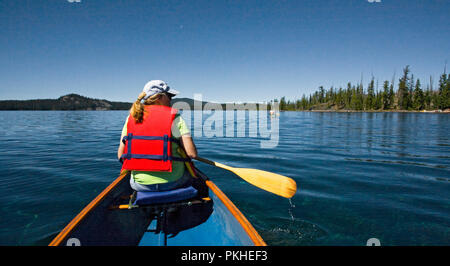 Ein über 60 Frau Paddeln ein Kanu auf Waldo See, einem vulkanischen Kratersee in der zentralen Oregon Kaskaden in der Nähe von Oak Ridge. Stockfoto