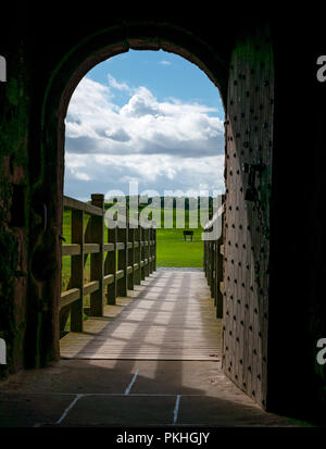 Auf der Suche durch alte verzierte Tür über moat Brücke, befestigte Tantallon Castle, North Berwick, East Lothian, Schottland, Großbritannien Stockfoto